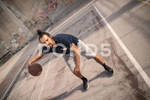Young couple playing basketball on an asphalt urban looking court Stock Photos