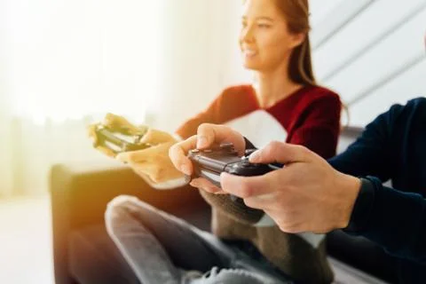 Young couple playing computer games, close-up view of game joysticks. Stock Photos