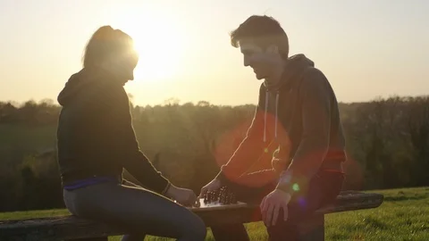 Young couple playing a game of chess outdoors in the countryside, in slow motion Vidéo 89536637