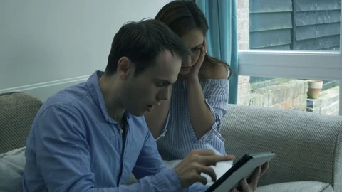 Young couple playing a game on tablet and winning big celebration Stock Footage 89922328