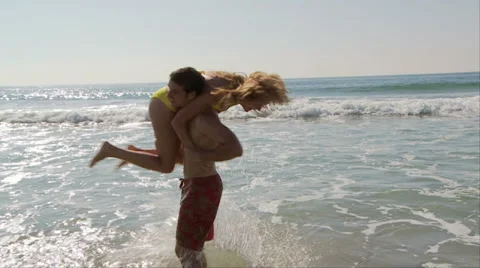 Young couple playing in ocean Video stock 934308