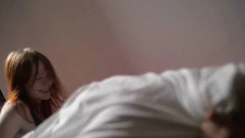 Young couple playing with pillows in bed Video stock 73542478
