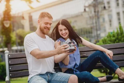 A young couple plays a game using virtual reality glasses on the street. Stock Photos