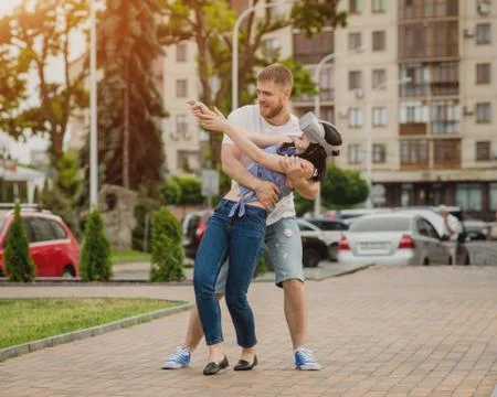 A young couple plays a game using virtual reality glasses on the street. Stock Photos
