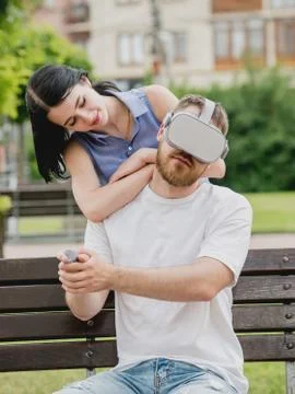 A young couple plays a game using virtual reality glasses on the street. Stock Photos