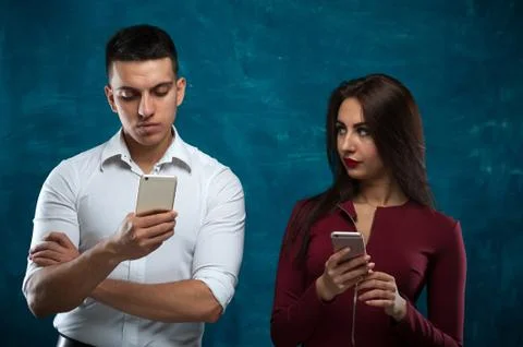Young couple posing on blue background Stock Photos