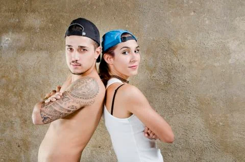 Young couple posing with hat opposite wall background Stock Photos