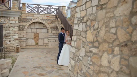 Young couple posing for a photo near a beautiful castle and stone wall with a Stock Footage