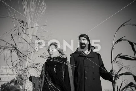 Young couple posing together with plant branches in the hand. Stock Photos