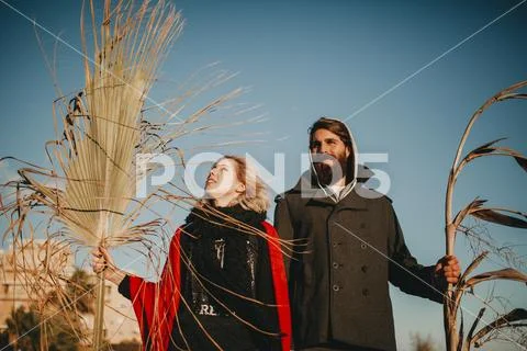 Young couple posing together with plant branches in the hand. Stock Photos