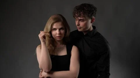 Young couple posing together in studio with dramatic lighting Stock Photos