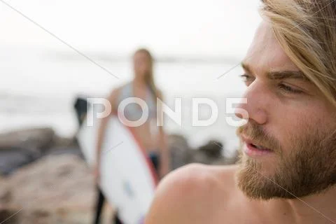 Young Couple Prepare To Go Surfing