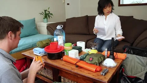 A young couple prepares emergency items to pack in their go-back in case of a na Stock Footage 169274838