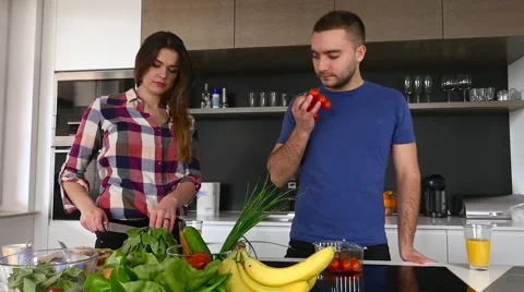 Young couple is preparing dinner. They are smelling tomatoes. Stock Footage 61855076