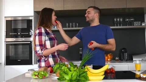 Young couple is preparing dinner. They are smelling tomatoes. Stock Footage 61858827
