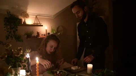 Young couple preparing a fresh salad together during a romantic evening 库存影片 330804614