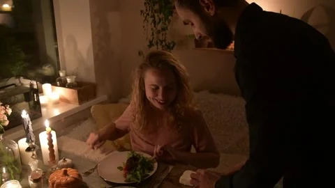 Young couple preparing a fresh salad together during a romantic evening 库存影片 330804649