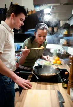 Young couple preparing lunch in kitchen Stock Photos