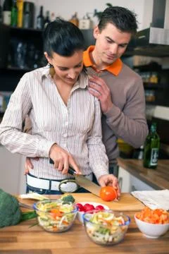 Young couple preparing lunch in kitchen Stock Photos