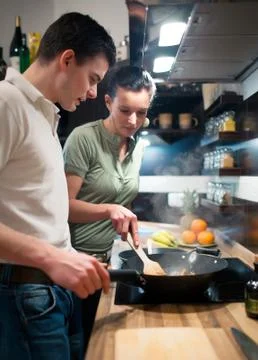 Young couple preparing lunch in kitchen Stock Photos