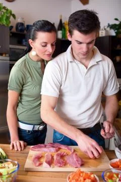 Young couple preparing lunch in kitchen Stock Photos