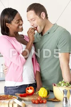 Young Couple Preparing Meal In Kitchen Stock Photos