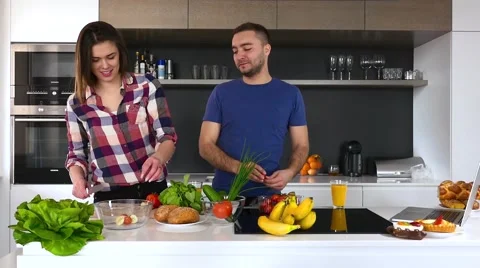 Young couple preparing salad in the kitchen. Slow motion. Video stock 61858574