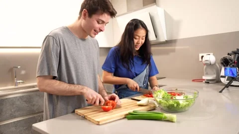 Young couple preparing salad together in modern kitchen Stock Footage 305236972