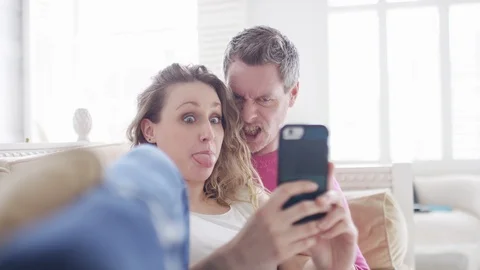 Young couple pulling faces as they take selfies on a cell phone together Stock Footage 88156321