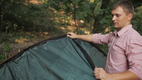 Young couple putting a tent in the woods Stock Footage 80366016