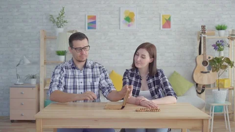 Young couple reading and studying a book in a modern apartment Stock Footage 108559417