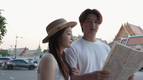 Young Couple Reading City Map Near Temple at Dusk Stock Footage 323352554