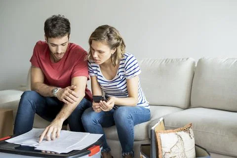 Young couple reading documents in their new house 写真素材