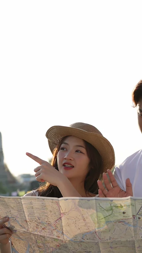 Young Couple Reading Map by Riverside Temple Landmark Stock Footage 323352151