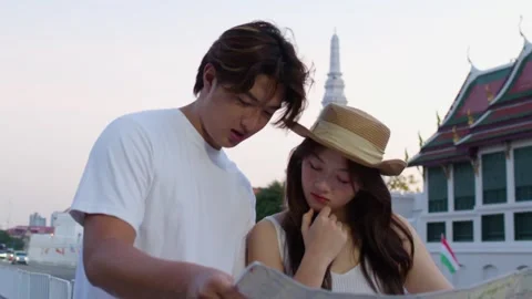 Young couple reading paper map at historic temple Stock Footage 324847962