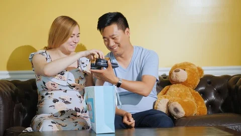 A young couple received a parcel with things for their future baby Stock Footage 125606975