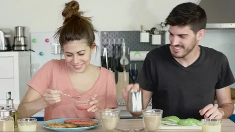 Young couple recently woken up having breakfast at home with some toasts with Stock Footage 133897330