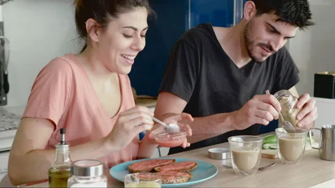 Young couple recently woken up having breakfast at home with some toasts with Stock Footage 133897454