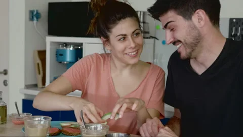 Young couple recently woken up having breakfast at home with some toasts with Stock Footage 133900346