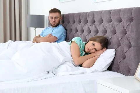 Young couple with relationship problems ignoring each other in bedroom Stock Photos