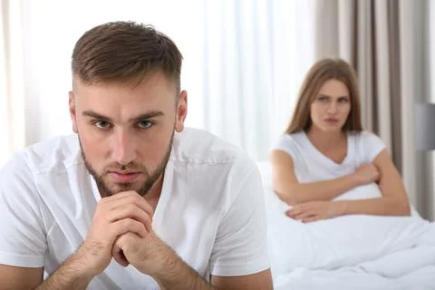Young couple with relationship problems ignoring each other in bedroom Stock Photos