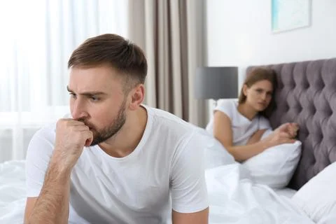 Young couple with relationship problems ignoring each other in bedroom Stock Photos