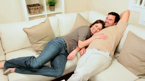 Young Couple Relaxing on Home Sofa Stock Footage
