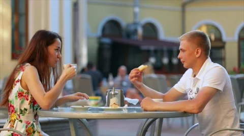 Young couple resting in a restaurant, drinking coffee and eating Cake. Video stock 66557690