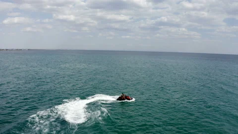 A young couple rides a jet ski on the emerald sea Stock Footage 146236472