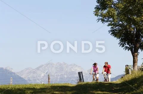 Young couple riding mountain bike, face to face Stock Photos