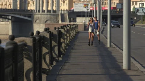 Young couple riding on rollers along the waterfront Stock Footage 41155135