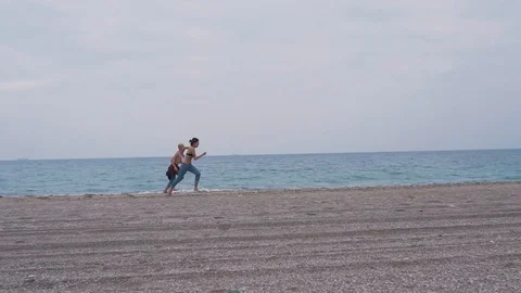 Young couple run on the beach Stock Footage 91775327