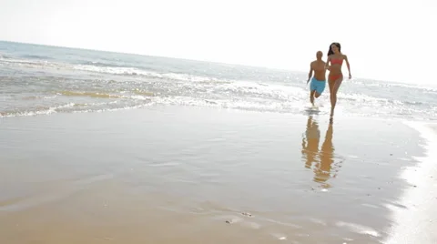 Young couple running and chasing on beach Stock Footage 43619852