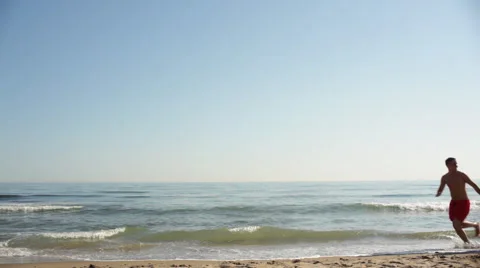 Young couple running on beach Stock Footage 43618165
